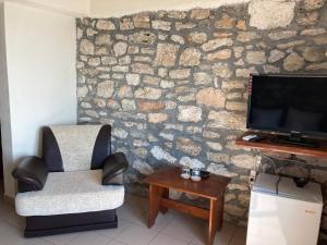 sala de estar con TV, silla y mesa en Prison de la Mer, en 2 Mai