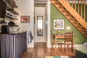 eine Küche und ein Esszimmer mit einem Tisch und einer Treppe in der Unterkunft Studio Koggeschip in Amsterdam