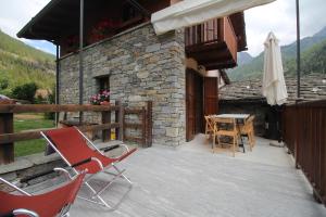 un patio con sillas, una sombrilla y una mesa en La terrazza en Ceresole Reale