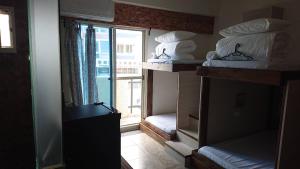 una habitación con dos literas y una ventana en 馬公港精品旅宿包棟烤肉附設租車, en Magong