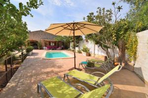 patio z parasolem i krzesłami oraz basenem w obiekcie Finca Son Fonto 097 by Mallorca Charme w Manacorze