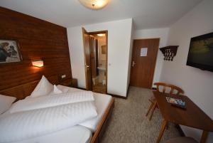 a hotel room with a bed and a desk and a bedroom at Haus Lattacher by Châtel Reizen in Stuben am Arlberg