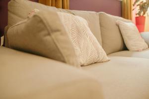 Bessemer House Apartments في Attercliffe: أريكة بيضاء عليها وسادتين