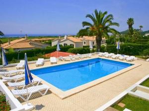una piscina con tumbonas y sombrillas en Villa Norde - A Family-friendly villa with pool and 3 bedrooms, en Son Bou