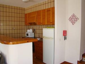 cocina con nevera blanca y microondas en Villa Norde - A Family-friendly villa with pool and 3 bedrooms, en Son Bou