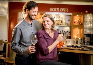 a man and a woman drinking wine in a bar at Boutique Hotel Hauser in Wels