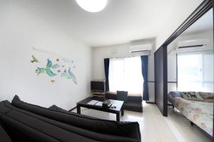 sala de estar con sofá y mesa en EX Itoman Apartment 603 en Itoman