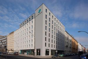 a large white building on a city street with cars at Motel One Berlin-Hackescher Markt in Berlin
