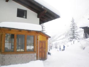 a snow covered building with people walking in the snow at Haus Lattacher by Châtel Reizen in Stuben am Arlberg