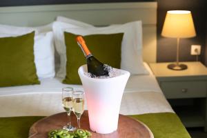 a bottle of wine sitting on top of a bed at Vigles Sea View, Philian Hotels and Resorts in Skiathos