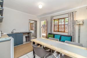 a kitchen and dining room with a table and chairs at Villa Roma - Luxury Accommodation in Centurion