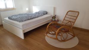 a bedroom with a bed and a rocking chair at Ferienwohnung Zellner in Deggendorf