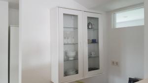 a white cabinet with glass doors in a room at Ferienwohnung Zellner in Deggendorf