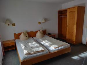 Bett in einem Zimmer mit zwei Kissen darauf in der Unterkunft Landgasthof Hotel Grüner Baum in Nürnberg