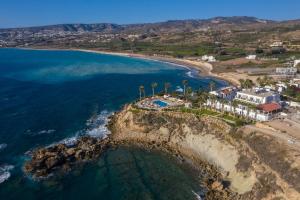 an aerial view of a beach with palm trees at Vrachia Beach Hotel & Suites - Adults Only in Paphos City
