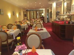 a restaurant with white tables and chairs and a buffet at Hotel Garni Wiestor in Überlingen