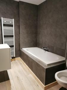 a bathroom with a bath tub and a toilet at Luxury Spa Hotel - Francofolies in Spa