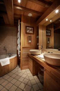 a large bathroom with two sinks and a tub and a tub at Hôtel Christiania in Val-d'Isère