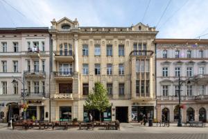 duży budynek ze stołami i ławkami przed nim w obiekcie Piotrkowska Welcome Apartments w Łodzi