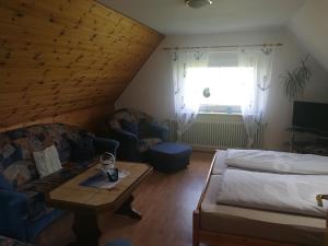 a bedroom with a bed and a couch and a table at Ferienwohnung Möwe, Perle im Dreieck Bensersiel, Neuharlingersiel, Esens in Neuharlingersiel