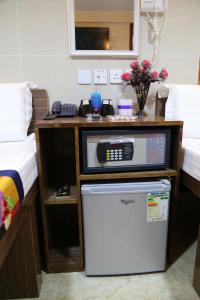 a room with a desk with a dishwasher and a bed at European Hostel in Hong Kong