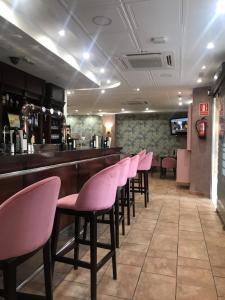 a row of pink chairs in a bar at Hostal Plaza in Marmolejo