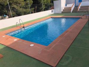 a large swimming pool with blue water in a building at Apartamento Balcón de San José, piscina, parking in San José