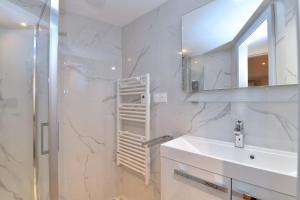 a white bathroom with a sink and a shower at Chez Madeleine in Châtenois