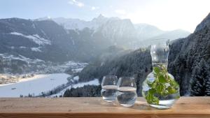 two glasses of water and a vase on a table at Hotel Ritzlerhof - Panorama und Spa in Sautens