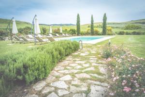 einen Pool im Garten mit Stühlen und Sonnenschirmen in der Unterkunft Villa d'Orcia - Homelike Villas in Castiglione dʼOrcia