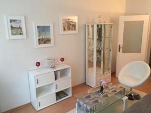 - un salon avec une commode blanche et une chaise dans l'établissement Altstadt-Ferienwohnung, à Tangermünde