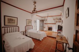 - une chambre avec 2 lits et une cheminée dans l'établissement Finca Santa Margarita, à Santaella