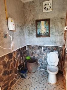 a bathroom with a toilet and a bucket at Heuan Na Khee in Udon Thani