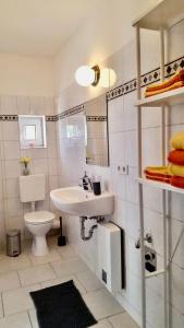 un bagno bianco con lavandino e WC di Ferienwohnungen in der Uckermark a Schönermark Altre 31 foto