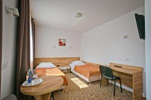 a hotel room with two beds and a table at Hotel Sezam Kraczkowa in Kraczkowa