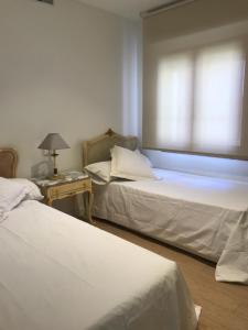 pokój z dwoma łóżkami i stołem z lampą w obiekcie LUXURY front the BEACH PRINCIPADO w mieście Benidorm