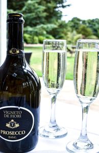 - une bouteille de champagne et deux verres sur une table dans l'établissement Dovecliff Hall Hotel, à Burton-on-Trent