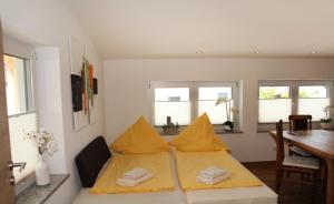 uma cama com lençóis amarelos num quarto com uma mesa em Ferienwohnungen Stöckl em Nittendorf