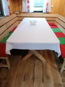 einen Tisch mit einem weißen Tischtuch auf einem Zimmer in der Unterkunft Świerkowe Zacisze Domki in Budzów