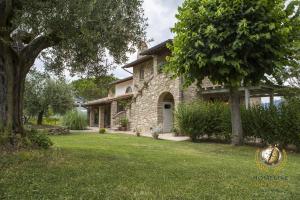 una casa de piedra con un árbol y un patio en Villa Il Segreto - Homelike Villas, en Vicolo Rancolfo