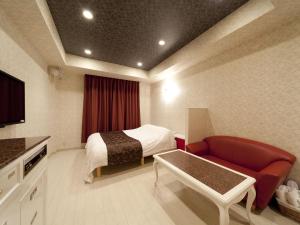 a hotel room with a bed and a couch at Hotel Fine Garden Matsuzaka III in Matsuzaka