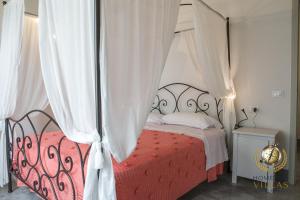 sypialnia z łóżkiem z baldachimem i białymi zasłonami w obiekcie Villa Il Segreto - Homelike Villas w mieście Vicolo Rancolfo