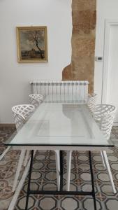 a glass table in a room with chairs at Palazzo Caratozzolo in Agrigento