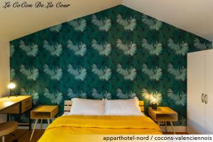 a bedroom with a green wall and a yellow bed at Le CoCon De La Cour in Valenciennes