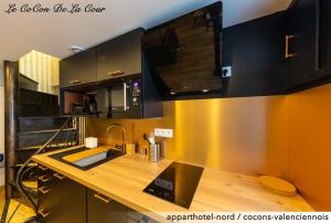 a kitchen with a wooden counter with a sink at Le CoCon De La Cour in Valenciennes