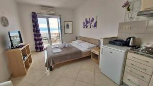 um pequeno quarto com uma cama e uma cozinha em Apartments Nemira em Omiš