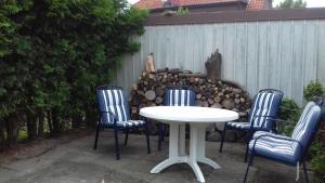 a white table with four chairs and a fence at Ferienwohnung, Monteurwohnung bis 6 Personen in Rottorf