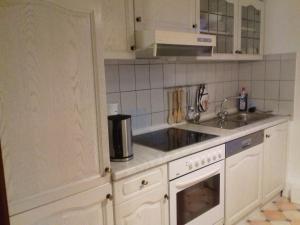 a white kitchen with a sink and a stove at Ferienwohnung, Monteurwohnung bis 6 Personen in Rottorf