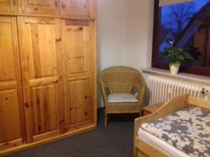 a bedroom with a cabinet and a chair and a bed at Ferienwohnung, Monteurwohnung bis 6 Personen in Rottorf +5 photos
