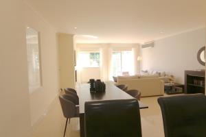 een woonkamer met een tafel en stoelen bij Villa Casa da Luz, Palmyra 173 - Clever Details in Vilamoura